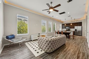 Kingwood townhouse for rent - A modern living room with a grey tufted sofa and a wooden floor.