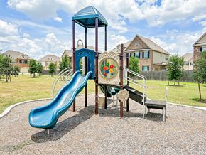 Pearland townhouse for rent - a playground with a slide and other toys in a yard with houses in the background