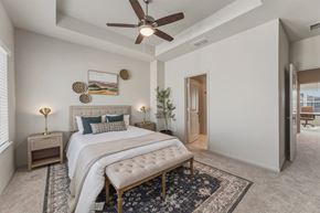 New Braunfels townhouse for rent - A bedroom with a large bed and a ceiling fan.