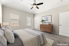 Kingwood townhouse for rent - A bedroom with a bed, dresser, and window.