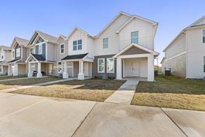 Denton townhouse for rent - A row of modern houses with white exteriors and dark roofs.