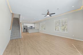 Denton townhouse for rent - A spacious room with a staircase and a ceiling fan.