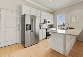 Kyle townhouse for rent - A modern kitchen with a stainless steel refrigerator and white cabinets.