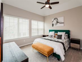 Denton apartment for rent - a bedroom with a bed and a ceiling fan