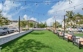 Katy townhouse for rent - a yard with tables and chairs and a pool with grass at Enclave at Mason Creek, Katy