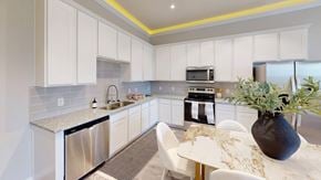 Atascocita townhouse for rent - A kitchen with white cabinets and a marble table.