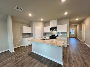 Youngsville house for rent - A kitchen with a granite countertop and white cabinets.