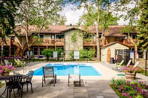 Winnipeg apartment for rent - a swimming pool in front of a house with a pool table and chairs