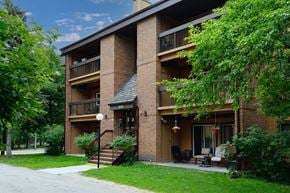 Winnipeg apartment for rent - A brick apartment building with a balcony and a patio.