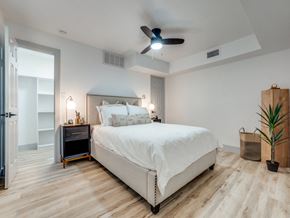 Dallas apartment for rent - a white bedroom with a bed and a ceiling fan