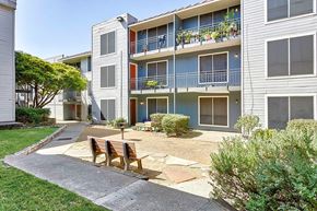 Dallas apartment for rent - a patio in front of an apartment building with a table and chairs