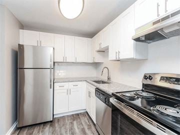 Bristol apartment for rent - a kitchen with stainless steel appliances and white cabinets