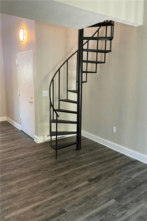 Wallingford apartment for rent - View of spiral staircase at Silvertree Apartments showing sand wood plank-style flooring and light tan walls