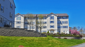 Norwich apartment for rent - a large apartment building on a sunny day with a green lawn