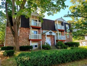 New London apartment for rent - a brick apartment building with trees and bushes in front of it