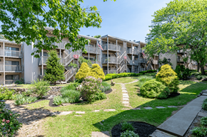 New London apartment for rent - an exterior view of an apartment building with a landscaped courtyard
