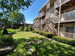 New London apartment for rent - the backyard of an apartment building with a yard and stairs