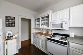 New London apartment for rent - a kitchen with white cabinets and a stove and a microwave