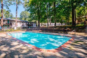 Decatur apartment for rent - A small pool surrounded by trees and a fence.