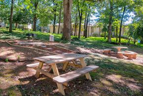 Decatur apartment for rent - A wooden picnic table sits in a grassy area with trees in the background.