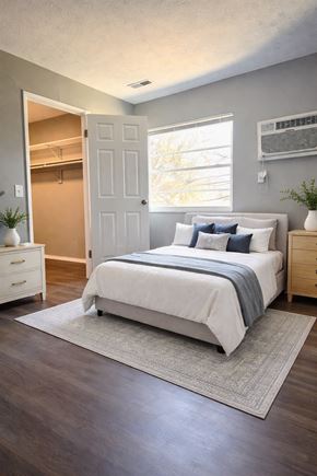 Cincinnati apartment for rent - A bedroom with a bed, nightstand, and a window.