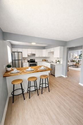 Huber Heights apartment for rent - A kitchen with a bar stool and a counter with plates on it.