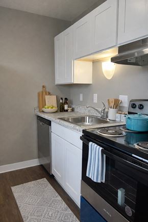 Cincinnati apartment for rent - A kitchen with a black stove top oven and white cabinets.