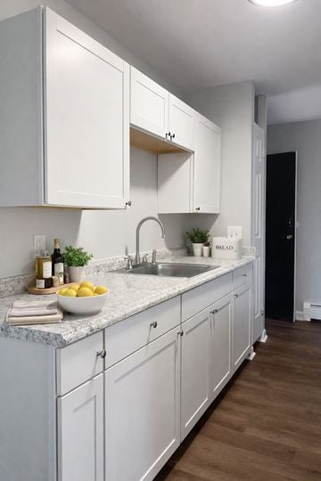Cincinnati apartment for rent - A kitchen with white cabinets and a marble countertop.