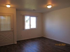 Cheyenne apartment for rent - an empty living room with a door and a window