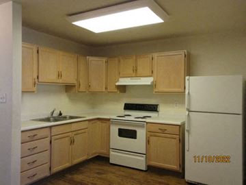 Cheyenne apartment for rent - a kitchen with white appliances and wooden cabinets