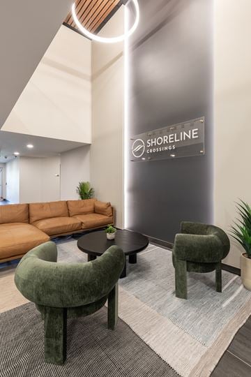 Lethbridge apartment for rent - A modern waiting area with a green chair and a sign that says Shoreline Crossings.