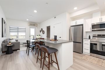 Lethbridge apartment for rent - A modern kitchen with a bar area and a dining table.