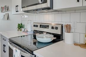 Saskatoon apartment for rent - A modern kitchen with a stove top oven and a microwave above it.
