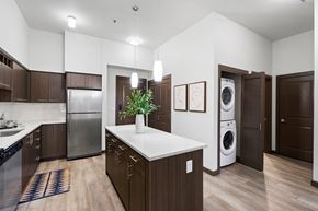 Hillsboro apartment for rent - A modern kitchen with dark wood cabinets and a white countertop.