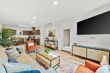 Brentwood apartment for rent - A living room with a glass coffee table and a couch with a striped pillow.