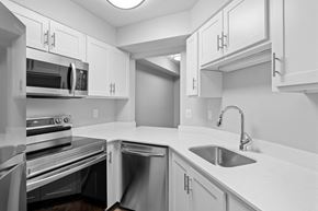 Beaverton apartment for rent - A modern kitchen with white cabinets and stainless steel appliances.