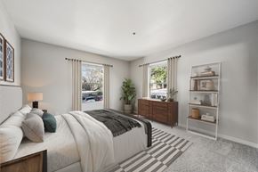 Benicia apartment for rent - A bedroom with a large bed, a nightstand, and a window with a view of the street.