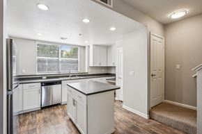 Petaluma apartment for rent - A kitchen with white cabinets and a black countertop.