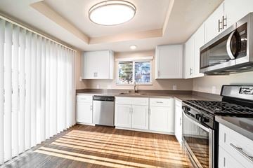 Alta Loma apartment for rent - A kitchen with white cabinets and a black stove top oven.