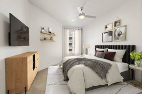 Denver apartment for rent - A bedroom with a large bed and a flat screen TV mounted on the wall.