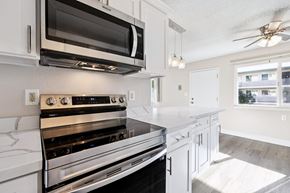 San Leandro apartment for rent - A modern kitchen with white cabinets and stainless steel appliances.