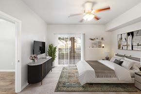 Sacramento apartment for rent - A bedroom with a large bed, a television, and a plant.