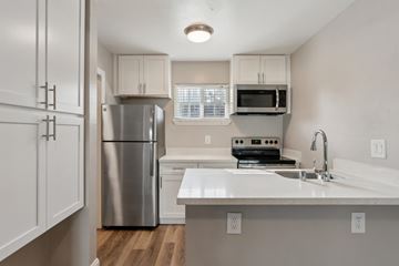 Pleasant Hill apartment for rent - A kitchen with white cabinets and a stainless steel refrigerator.
