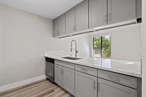 Roseville apartment for rent - an empty kitchen with white cabinets and a window