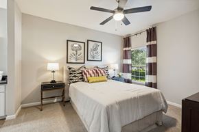 Vacaville apartment for rent - A bedroom with a bed, nightstand, and two wall art pieces.