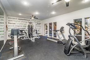 Cameron Park apartment for rent - A gym room with a row of treadmills and a wall of motivational words.