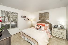 Cameron Park apartment for rent - A bedroom with a bed, nightstand, and lamp.