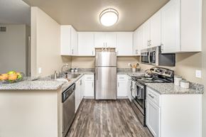 Cameron Park apartment for rent - A kitchen with white cabinets and a granite countertop.