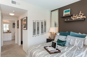 Monrovia apartment for rent - A bedroom with a bed, nightstand, and a laptop on the bed.