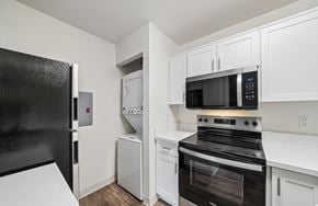 Livermore apartment for rent - A black refrigerator is in a kitchen with white cabinets.